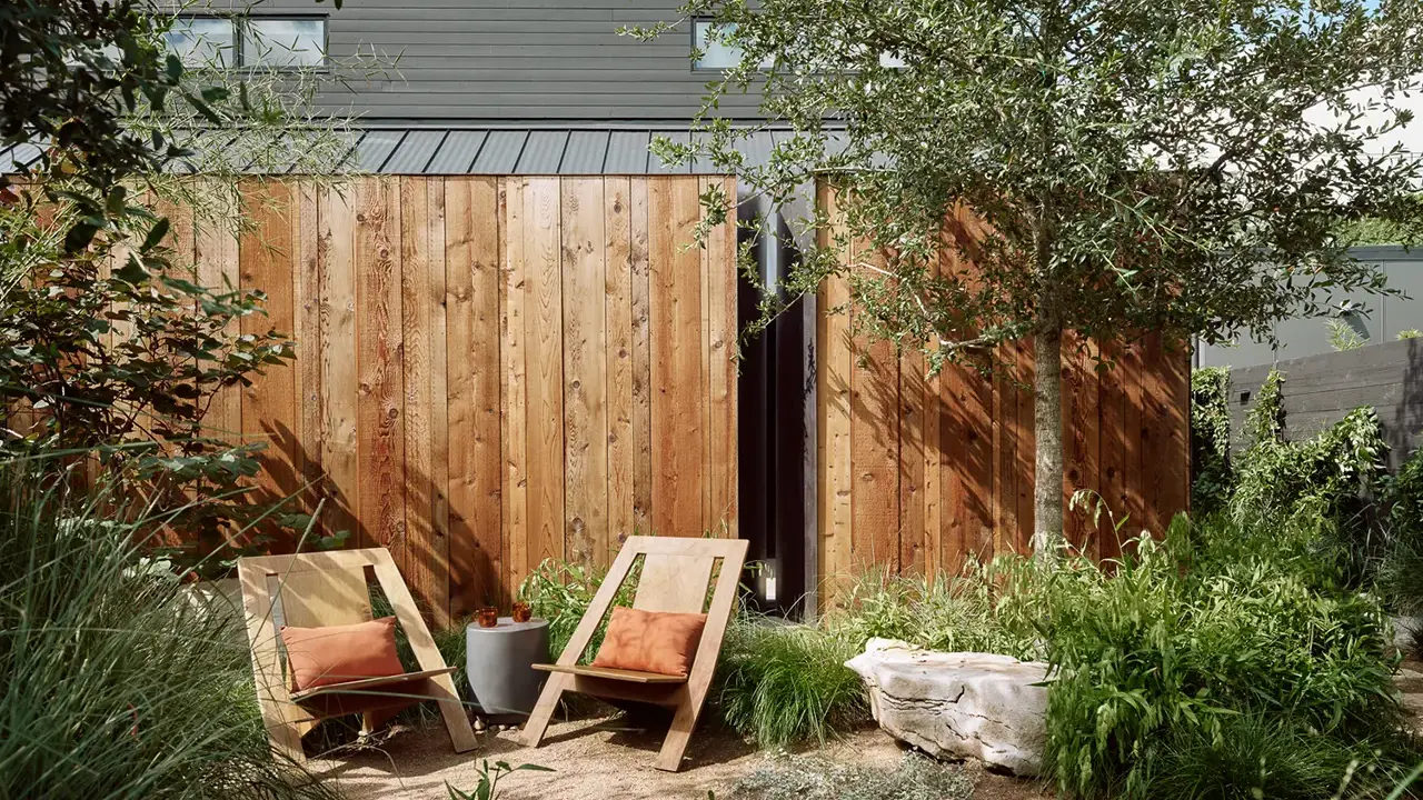 Frame SoCo courtyard garden with lush greenery, a winding path, and a calming atmosphere