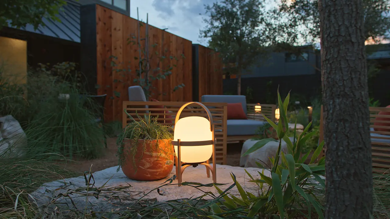 Frame Hotel SoCo — walled garden at dusk, glowing lantern and native plantings