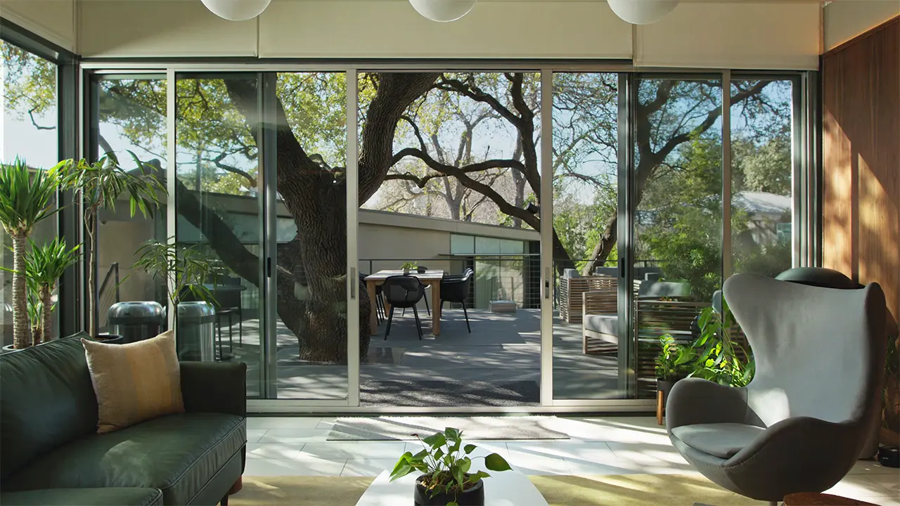 Frame Treehouse common room opening onto the courtyard beneath the live oak canopy