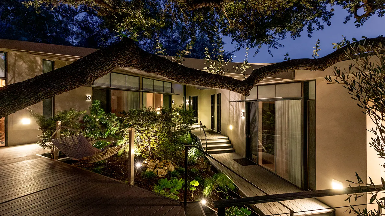 Frame Hotel Treehouse — courtyard and curved canopy at dusk
